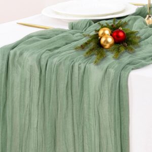 “Socomi sage green cheesecloth table runner draped on rustic farmhouse dining table”